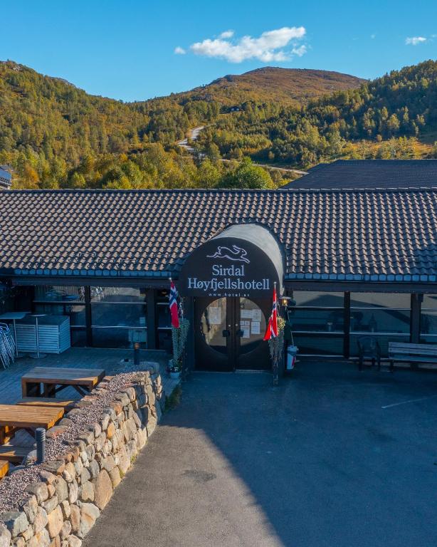 a building with a table and benches in front of it at Sirdal Høyfjellshotell in Fidjeland