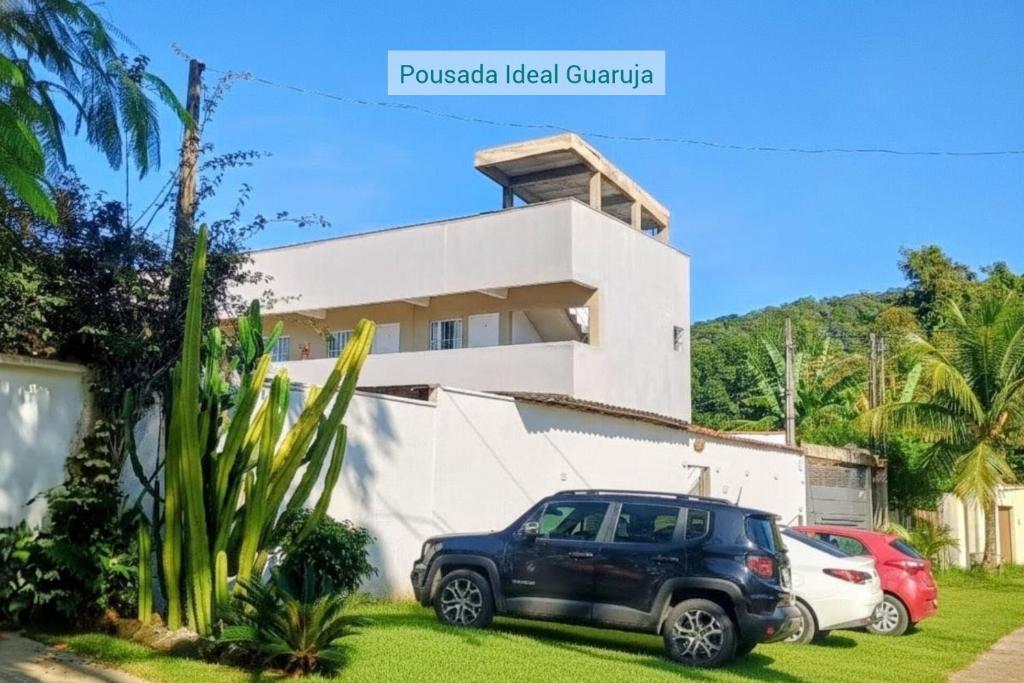 a black suv parked in front of a house at Pousada Ideal Guarujá - Estúdios Família & Quartos in Guarujá