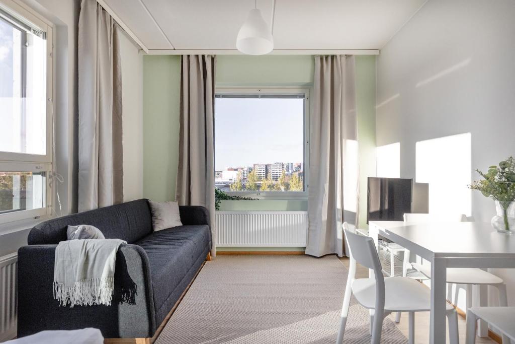 a living room with a couch and a table and a dining room at Spot Apartments Oulu in Oulu