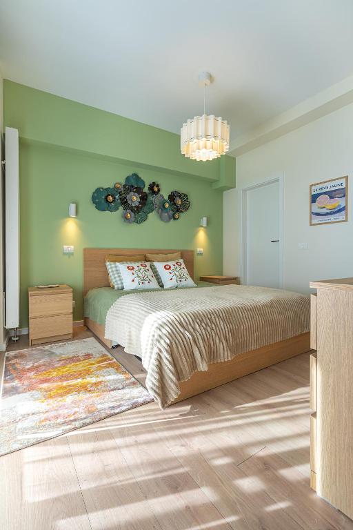 a bedroom with a large bed and green walls at GreenVista 20 minutes by Therme & Airport in Voluntari