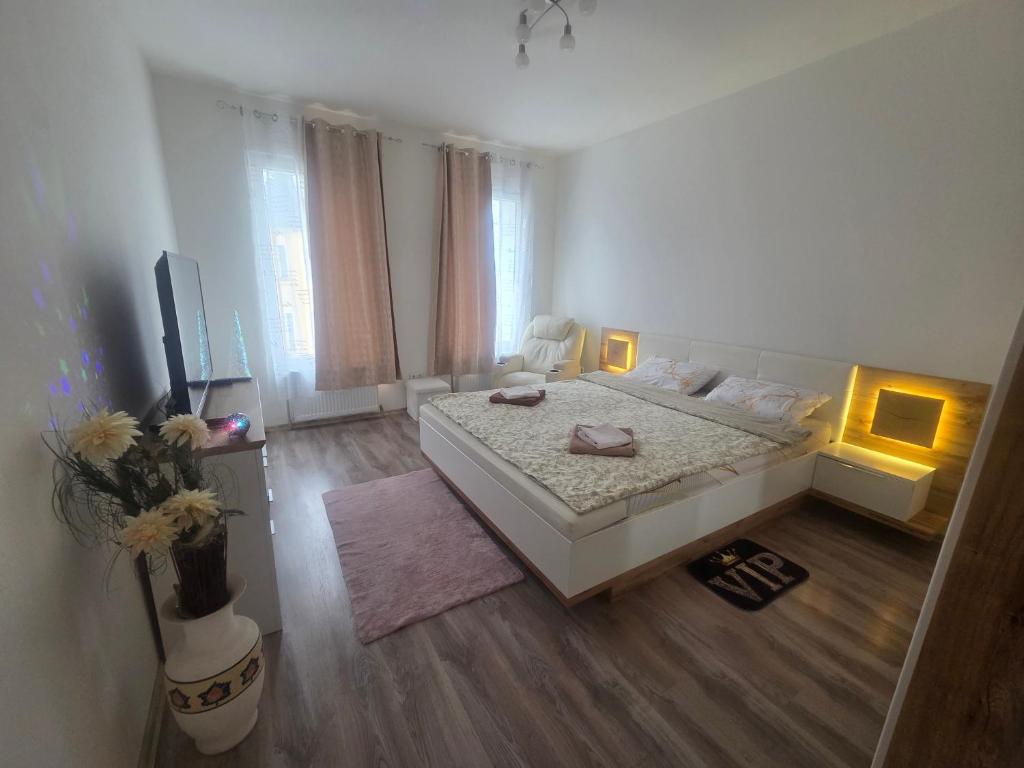 a large white bedroom with a bed and a television at 3 Apartments Angels o k b in Altenburg