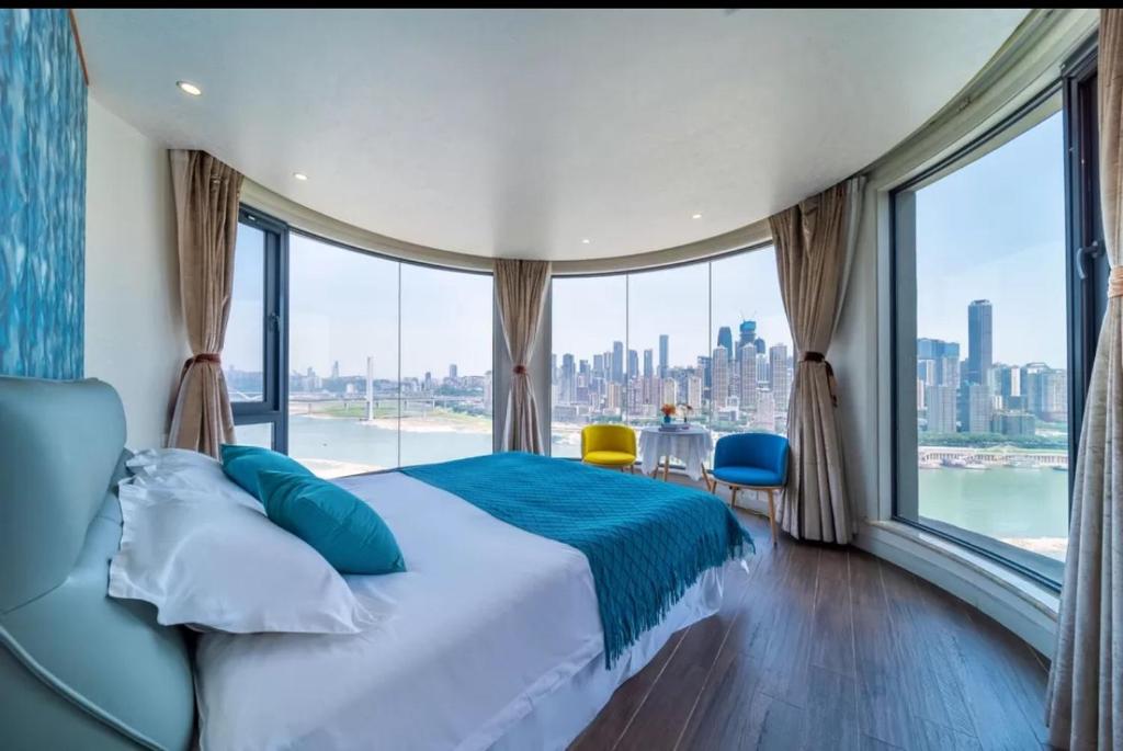 a bedroom with a large bed and a large window at 悦江阁美宿 in Chongqing