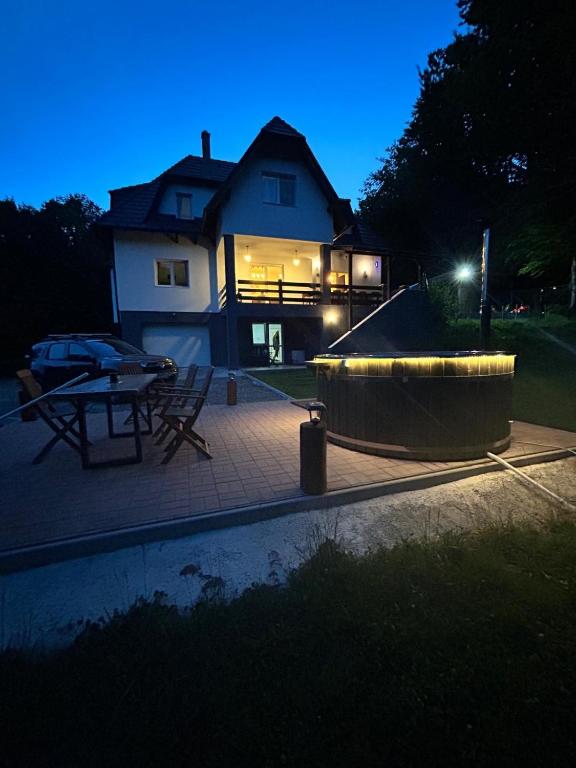 a house lit up at night with a patio at Flow House in Satu Mare