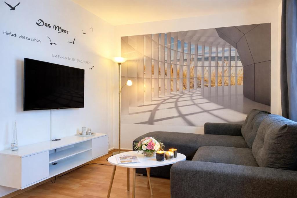 a living room with a couch and a tv at Appartementhaus Sonnenschein - 250m zum Strand im Zentrum von Binz in Binz