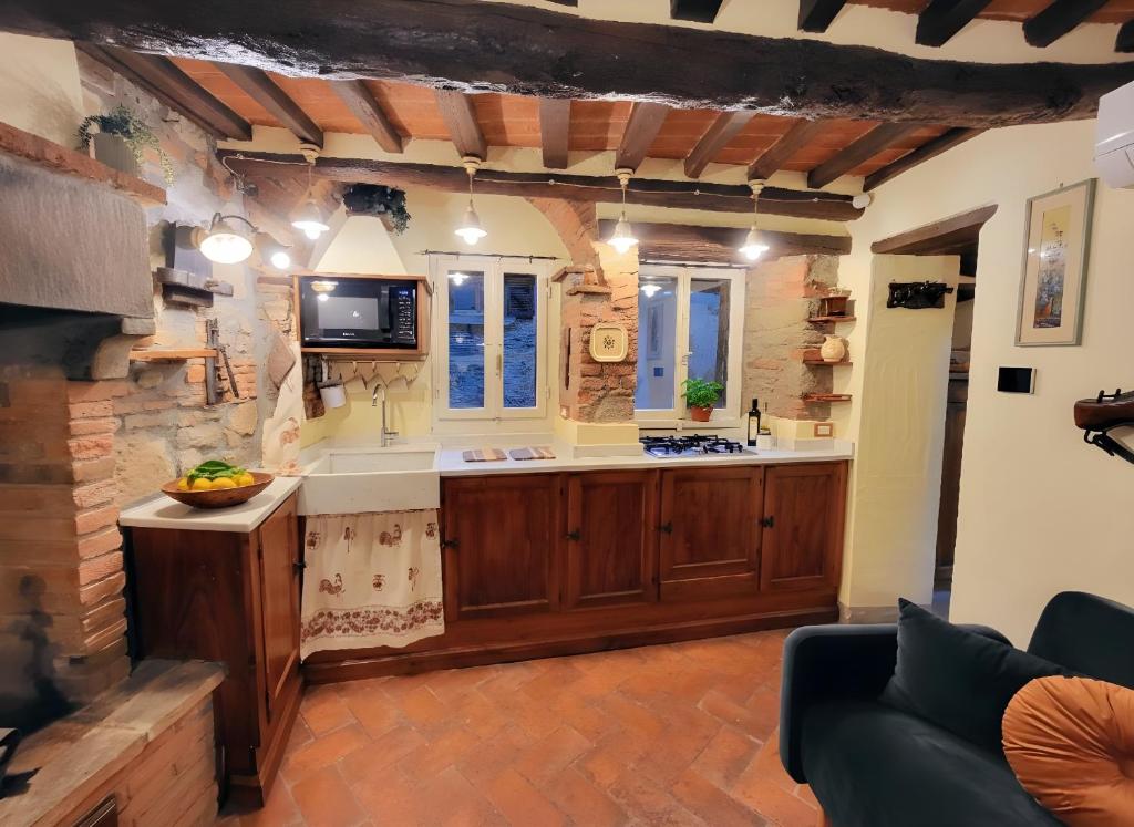 a large kitchen with wooden cabinets and a tv at Casa della Rosa in Cortona