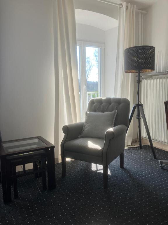 a living room with a chair and a lamp at Mosel-Studio-Apartment in Lieser