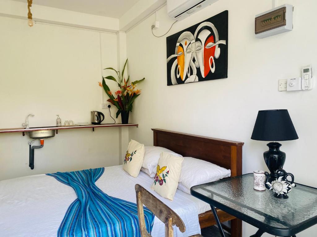 a bedroom with a bed and a table with a tableablish at ELOP Resturant & Villa in Piyadigama