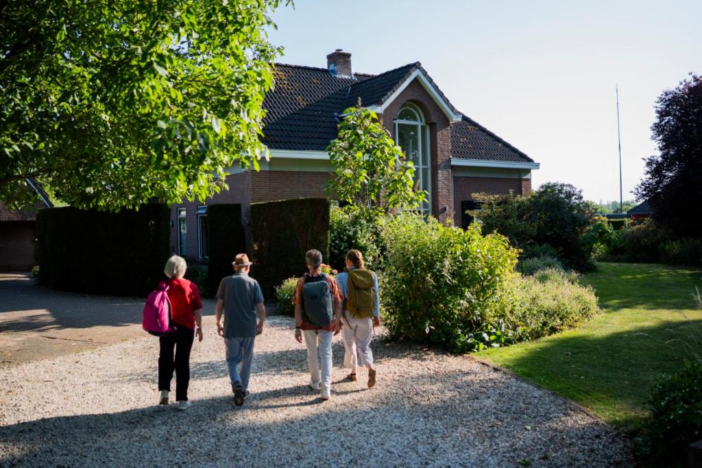a group of people walking in front of a house at de lange adem in Millingen aan de Rijn