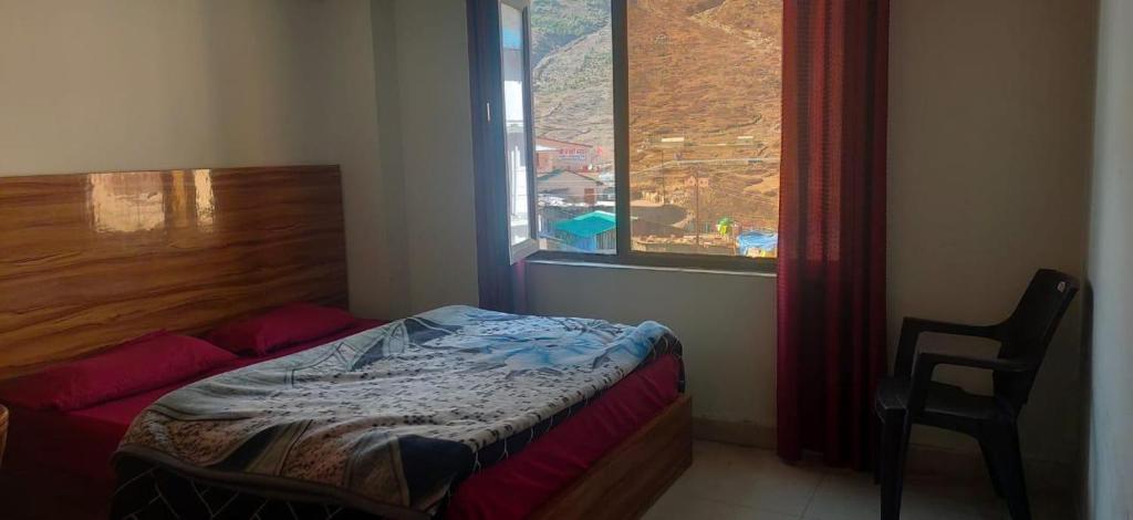 a small bedroom with a bed and a window at Hotel Radha Krishana in Māna
