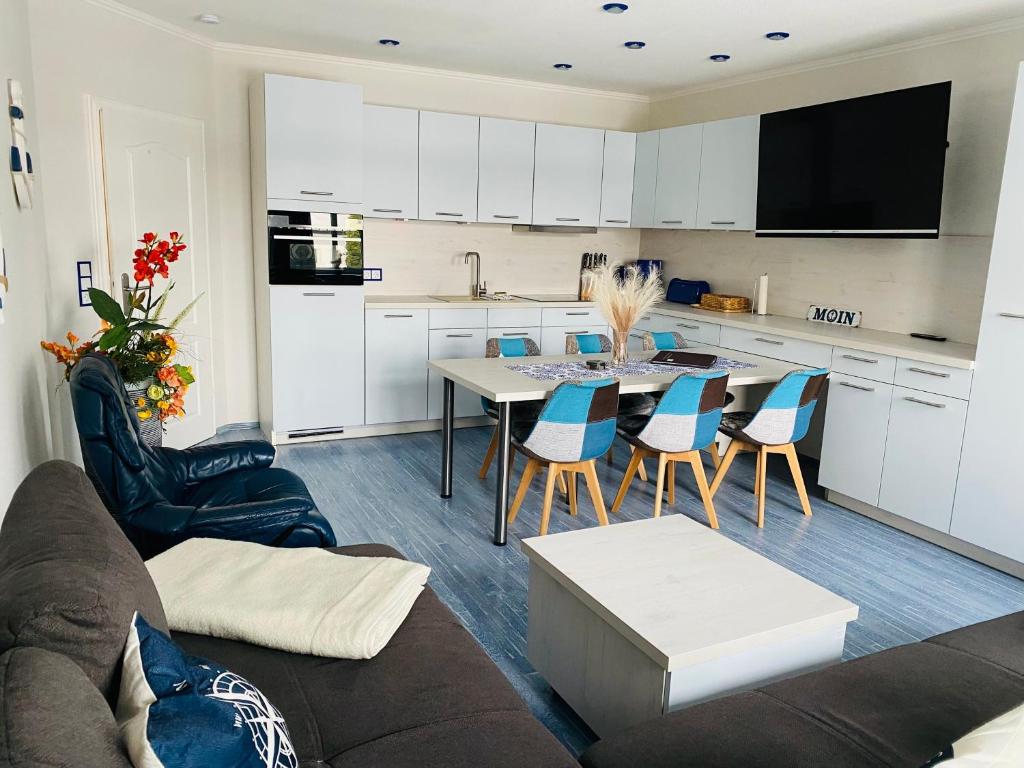 a kitchen and living room with a table and chairs at Kieferneck Ferienwohnung Hedi in Karlshagen