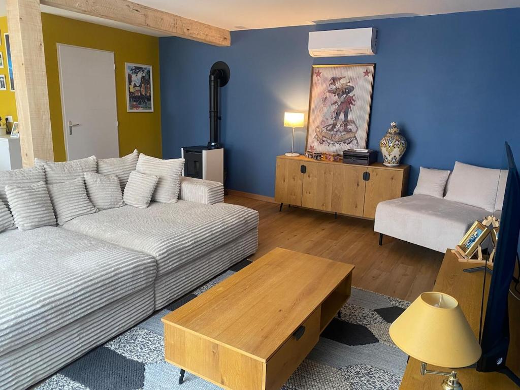 a living room with a couch and a table at La Grange des Pépettes ! in Saint-Germain-des-Fossés