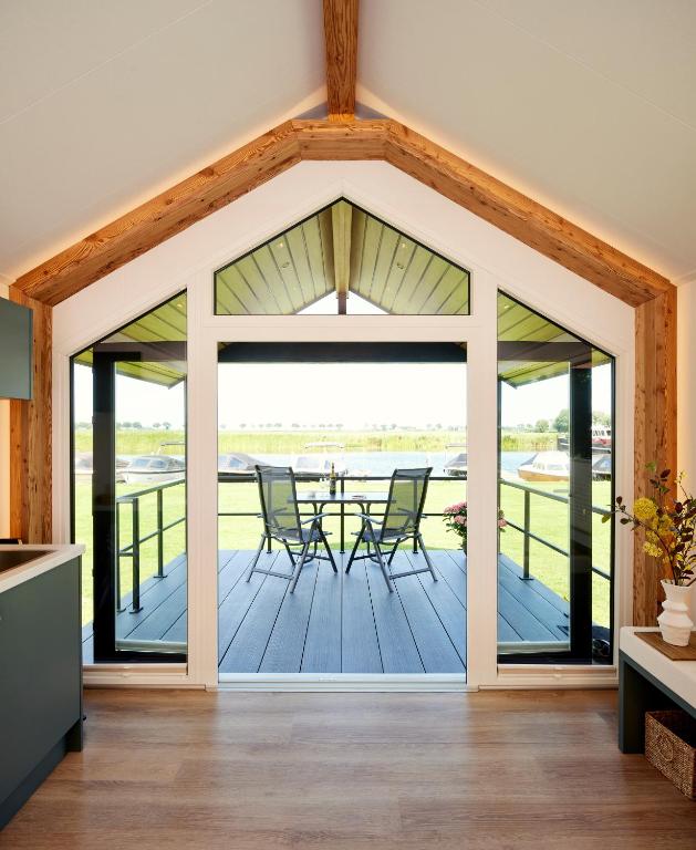 an open living room with a table and chairs on a deck at Tussen de Diepen in Blokzijl