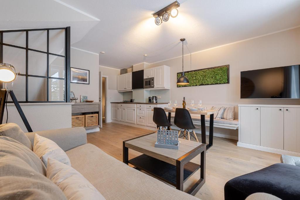a living room with a couch and a dining room at Küstennest in Wenningstedt