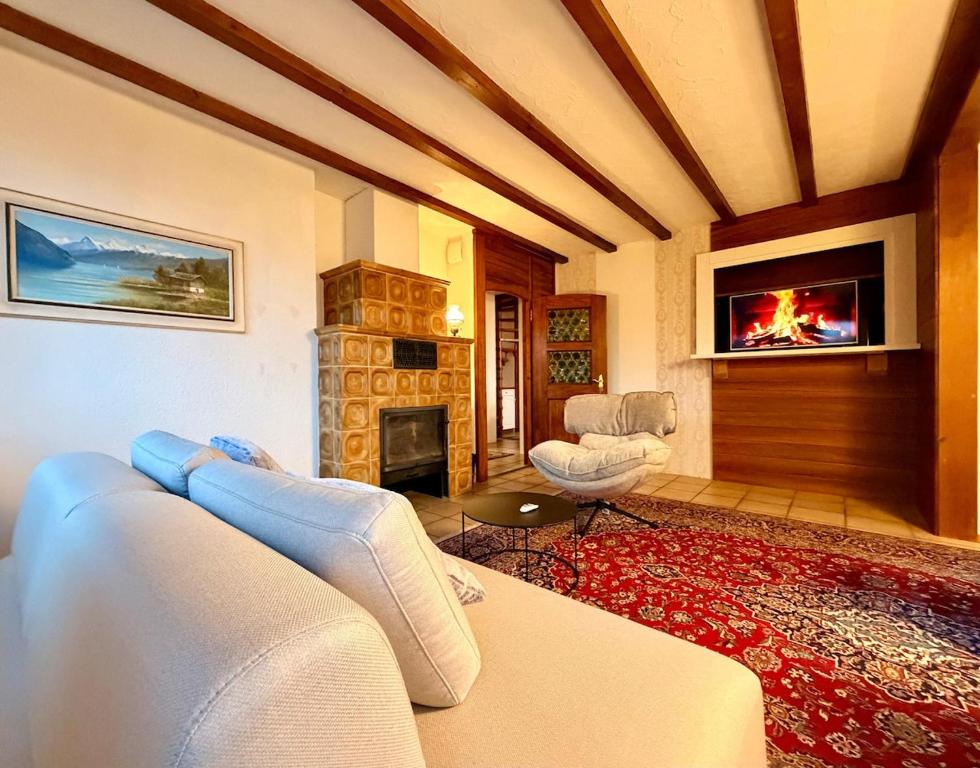 a living room with a couch and a fireplace at Chalet Apartment Faulensee in Faulensee