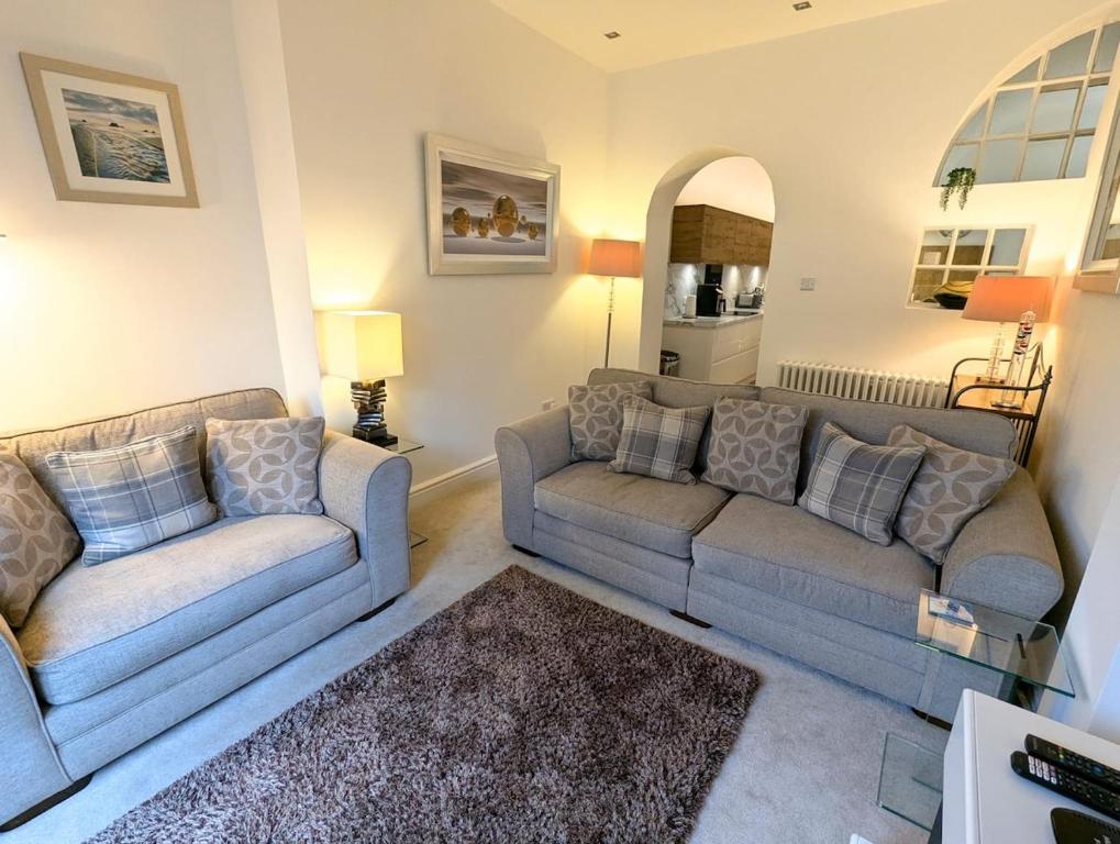 a living room with two couches and a rug at 2 Bedroom Unique Converted Constabulary in Nantwich