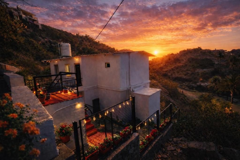 a building with a sunset in the background at Sky Mount Villa in Mount Ābu