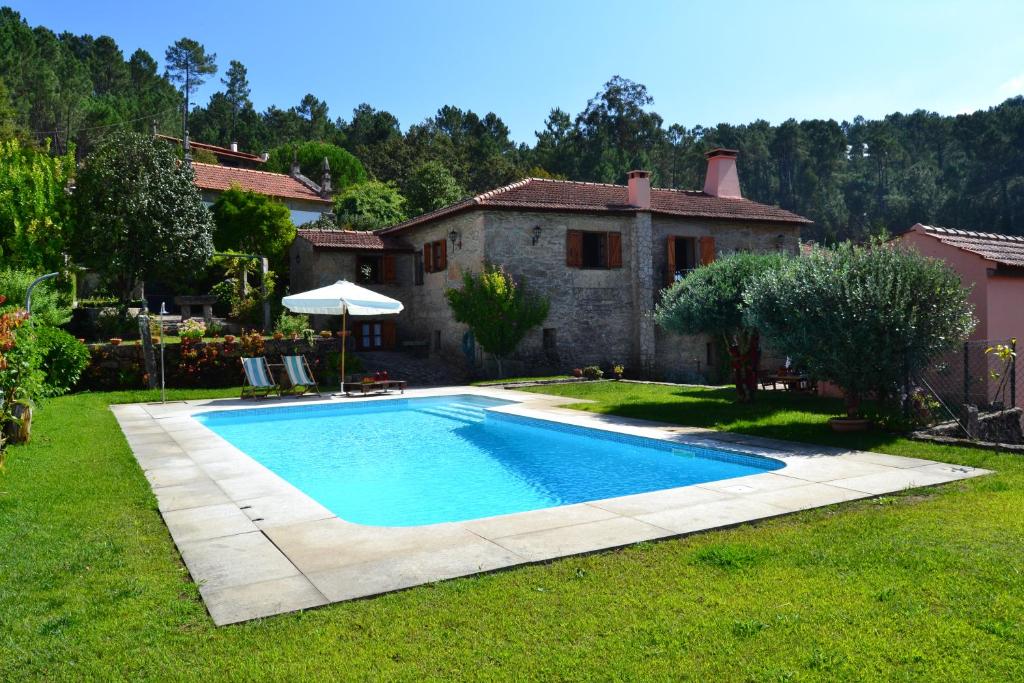 a swimming pool in the yard of a house at Casa de Fujacos in Valença