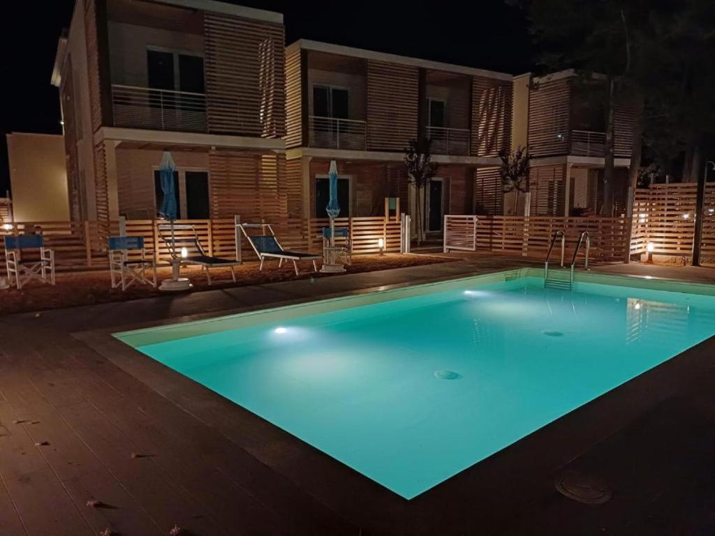 a swimming pool at night in front of a house at Acquaviva Suite in San Vincenzo
