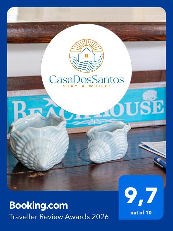 two white glass vases sitting on a table with a sticker at Casa dos Santos in Ponta Delgada