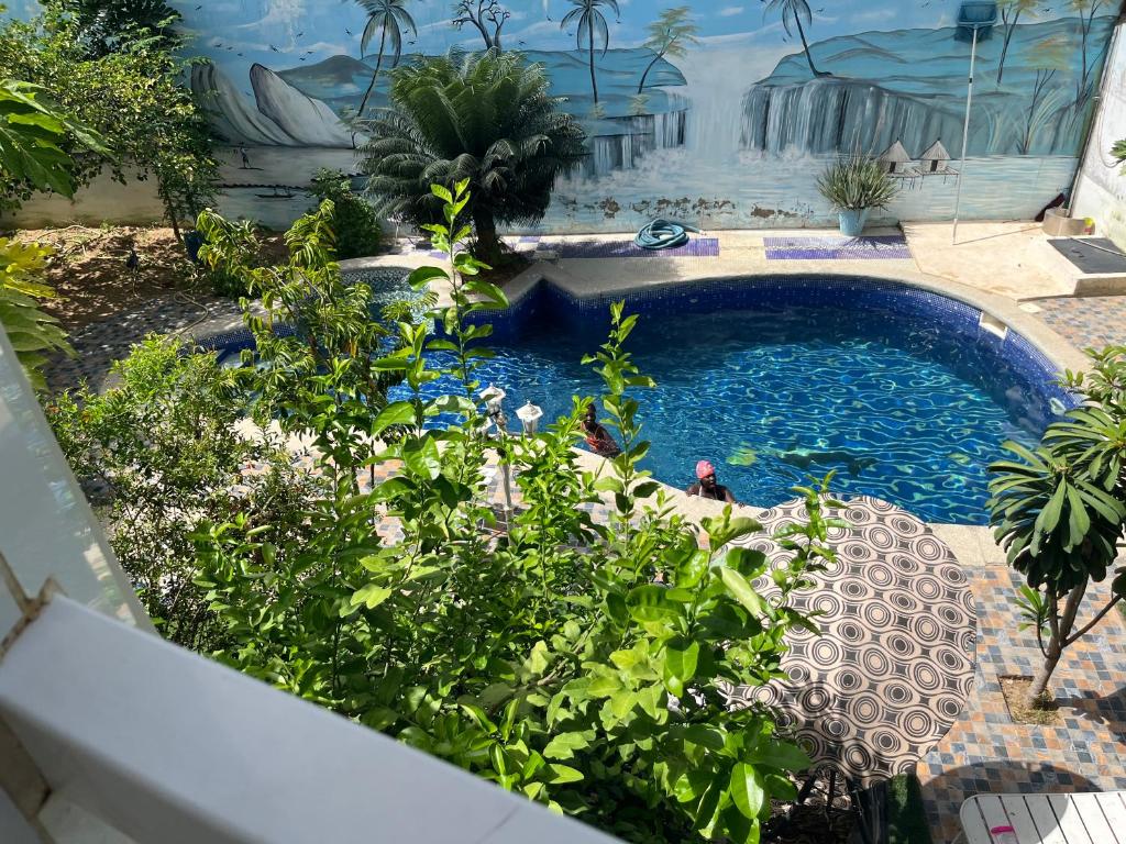 a swimming pool in the middle of a garden at Venusia Villa in Darou Rhamane