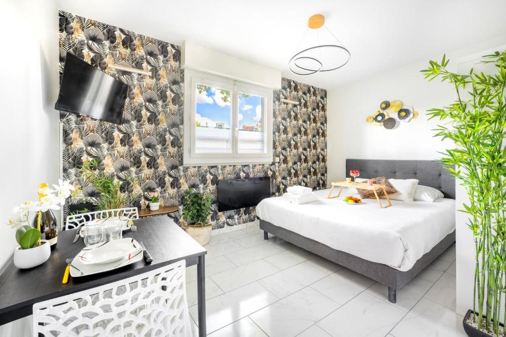 a bedroom with two beds and a desk with plants at BnGo I Le Cosy des Canuts I Parking, 2p, proche hôpital in Caluire-et-Cuire