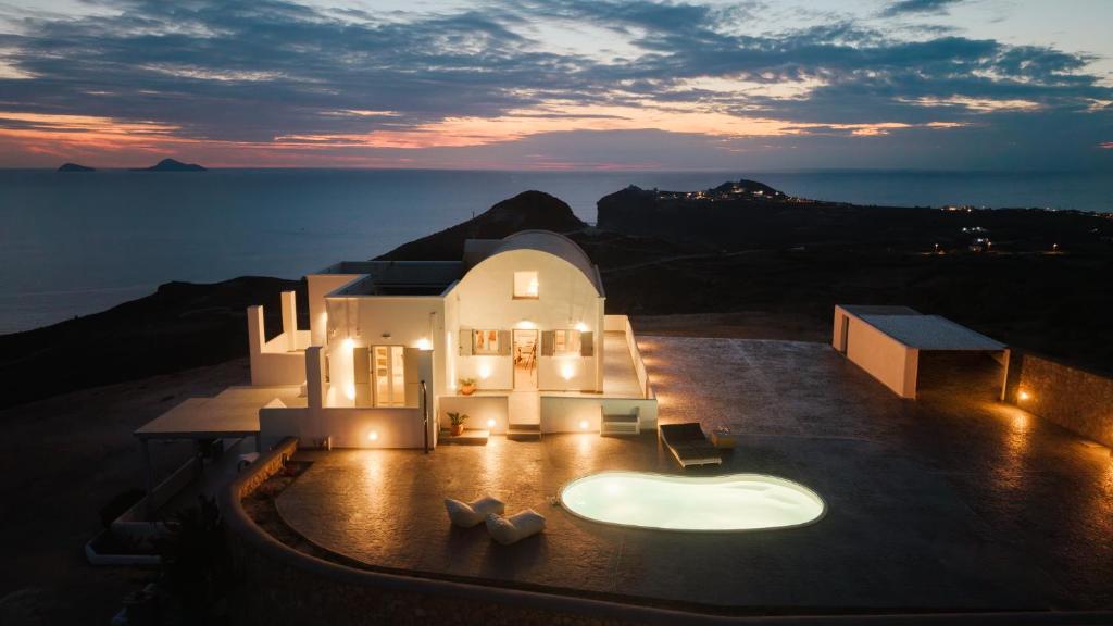 a villa with a view of the ocean at sunset at Occhio-Nero Cycladic Private Villa with Pool & Sunset View Jacuzzi in Akrotiri