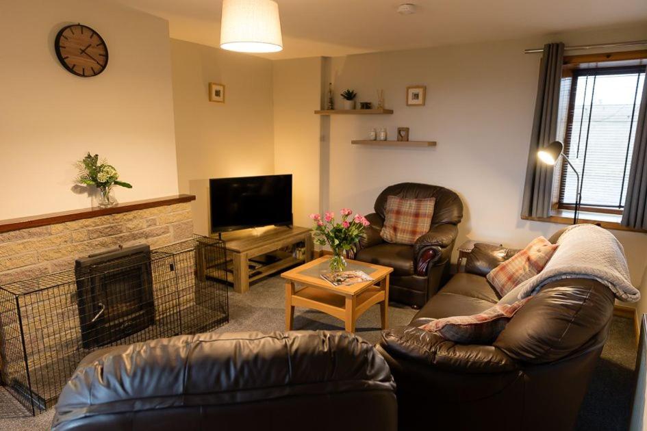 a living room with a couch and a fireplace at Taftnica in Burray Village