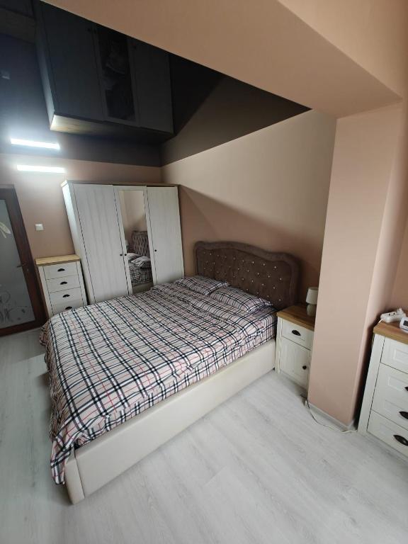 a bedroom with a bed with a checkered blanket at Sunset Home Apartment in Galaţi