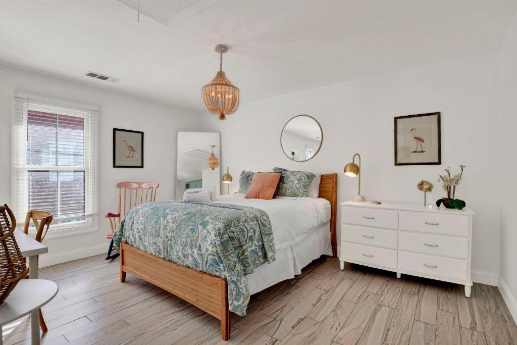 a bedroom with a bed and a dresser and a mirror at Crawford Carriage House in Savannah