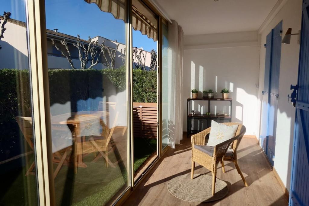 a balcony with a table and a chair at Lora Apartment with Garden & Pool in Mandelieu-La Napoule