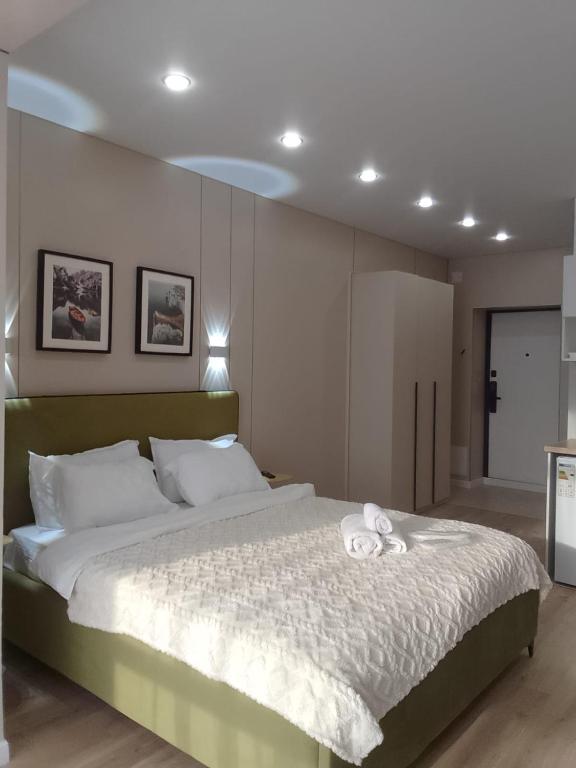a bedroom with a large bed with towels on it at WOODSPACE Apartment in Shchūchīnsk