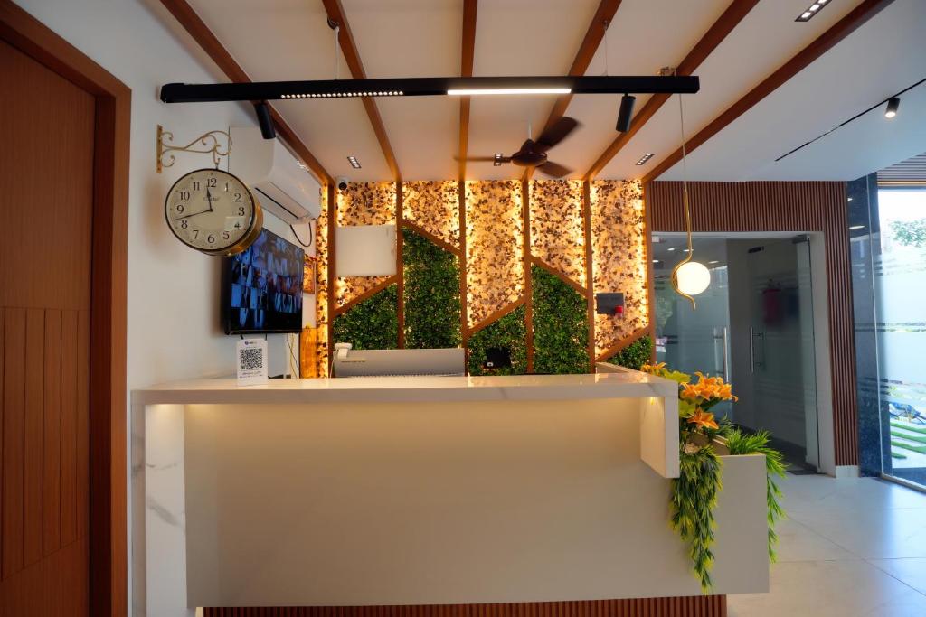a lobby with a reception desk and a clock at Avenue A boutique hotel in Vijayawāda
