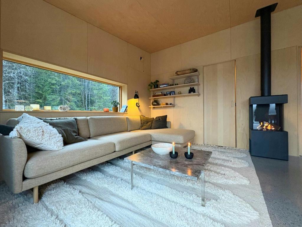 a living room with a couch and a tv at Architect-Designed Cabin By Lake With Sauna in Homle