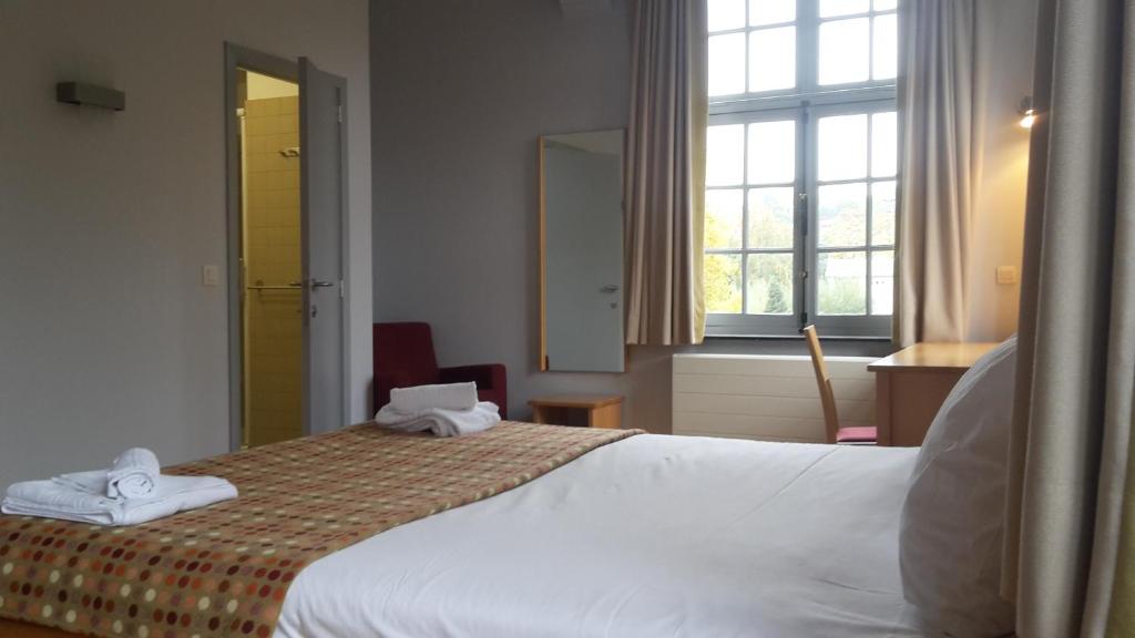 a hotel room with a bed and a window at Irish College Leuven in Leuven