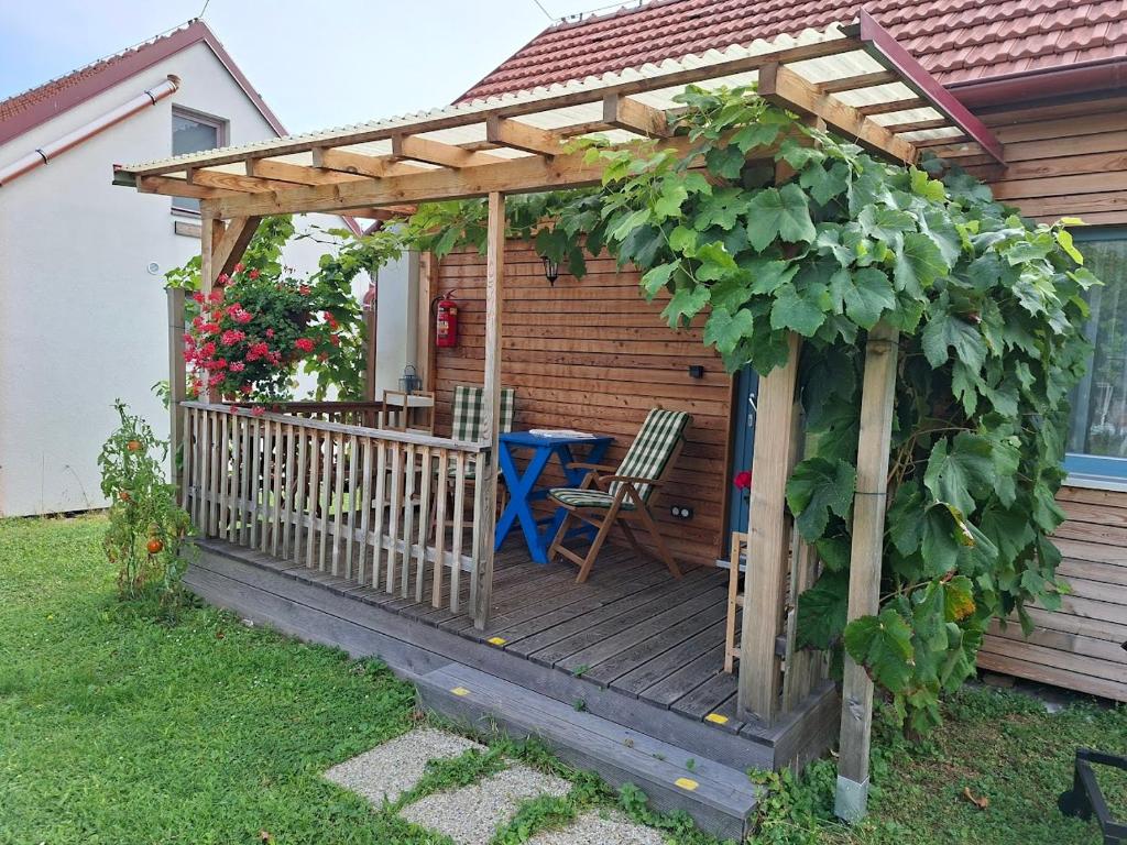 a wooden pergola with a table and a chair on a deck at Pavlov24 - Domeček u potoka in Pavlov