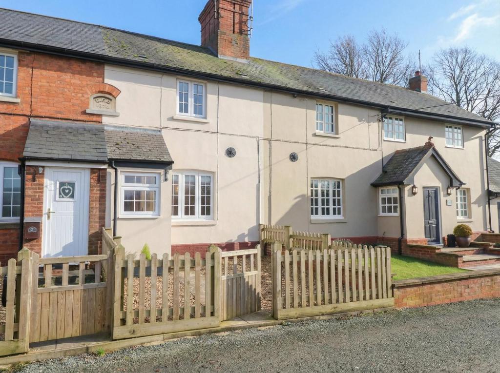 a white house with a wooden fence at Little Launde Cottage in Leicester
