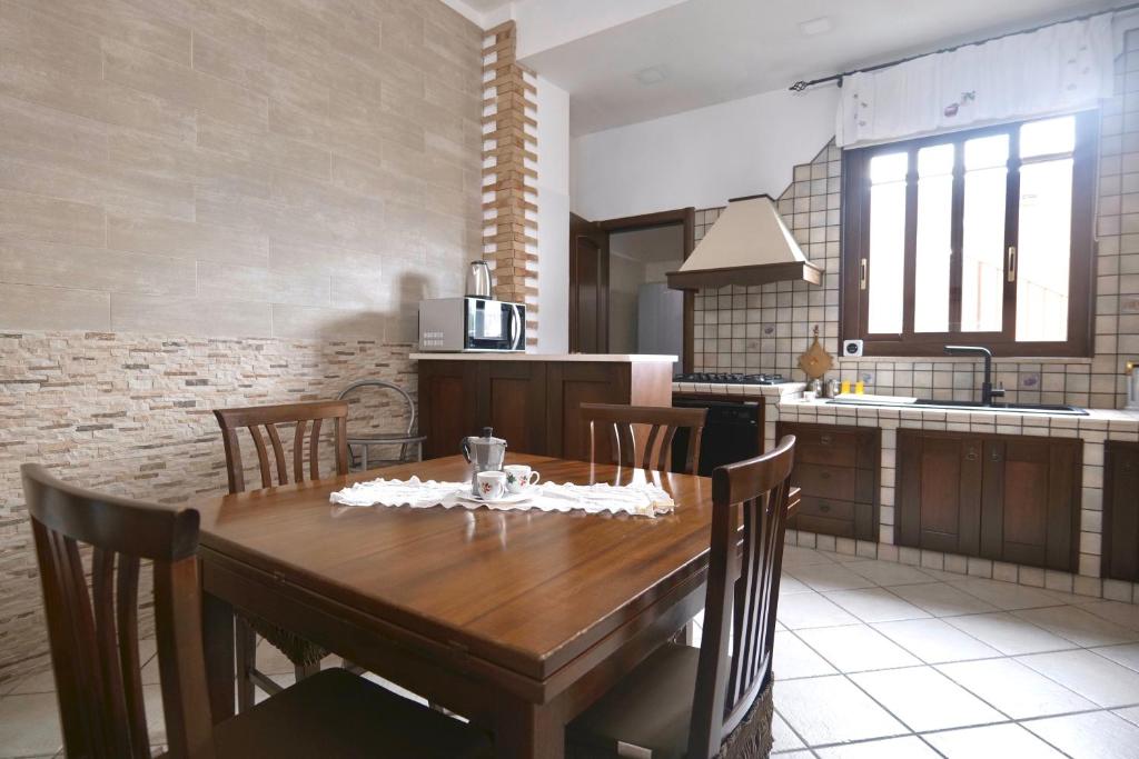 a kitchen with a wooden table and chairs in a kitchen at Free Parking - Maria House in Torre del Greco