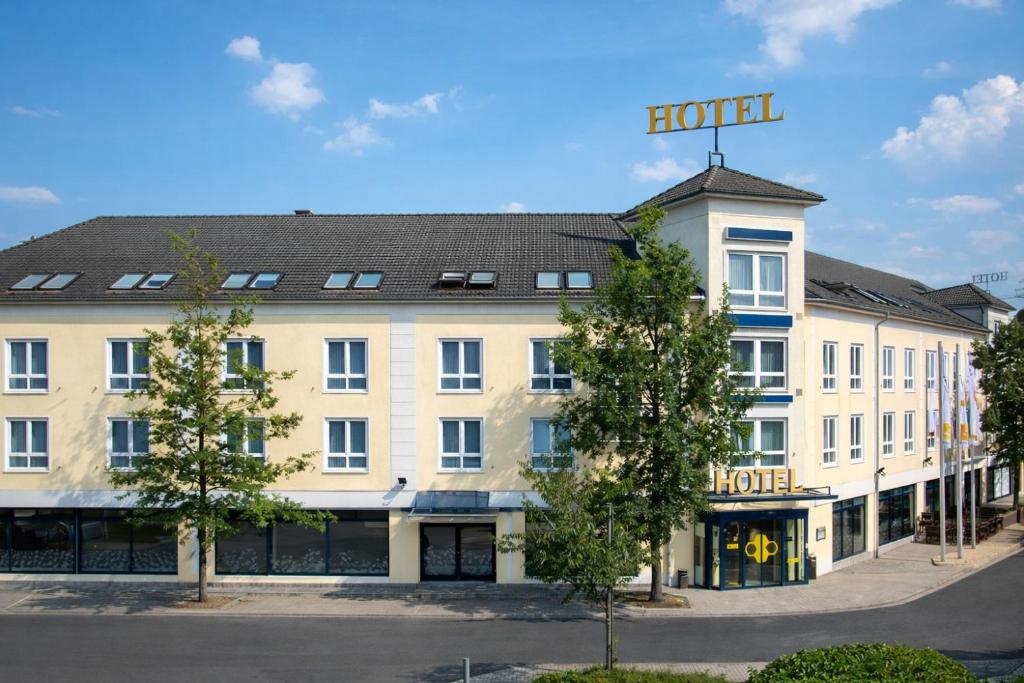 a building with a hotel sign on top of it at Best Western Premier Airporthotel Berlin in Schönefeld