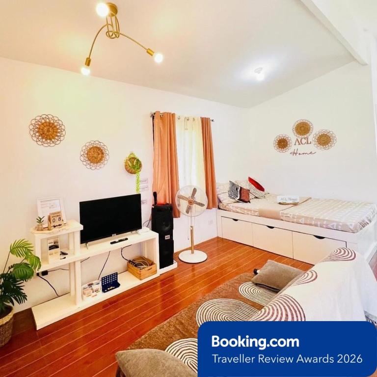 a living room with a bed and a television at ACL HOME -Island Staycation in Lapu Lapu City