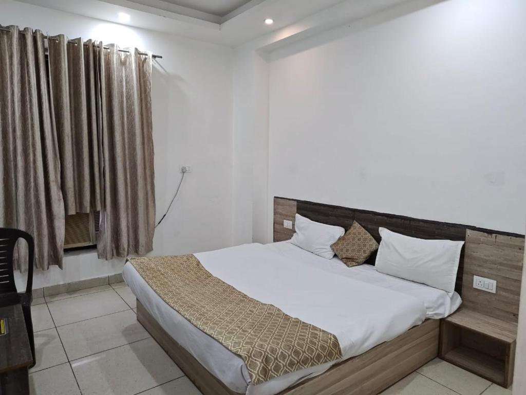 a bedroom with a large bed with white sheets and pillows at Prem Resort in Vrindāvan