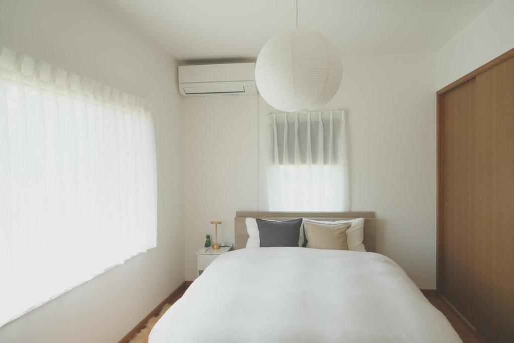 a bedroom with a large white bed and a window at Aioi house in Tsubetsu