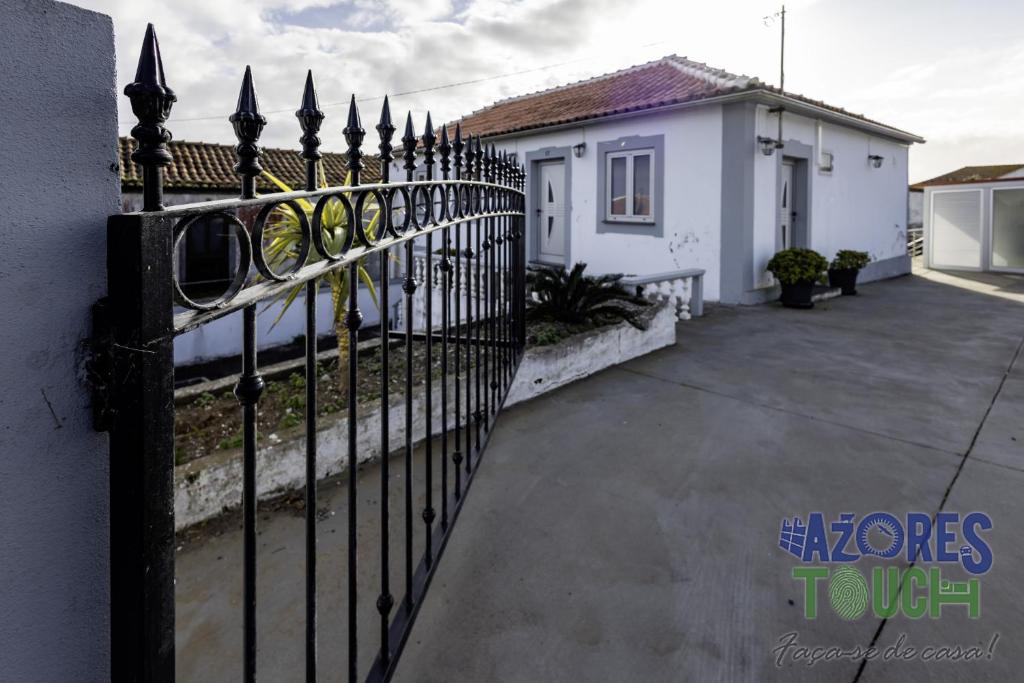 a black wrought iron fence in front of a house at Sunset Pool House T2 in Feteira