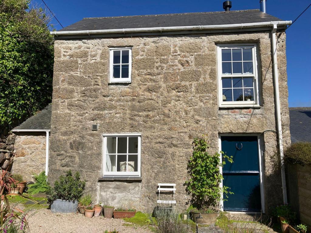 a stone house with a bench in front of it at The Old Studio in Penzance