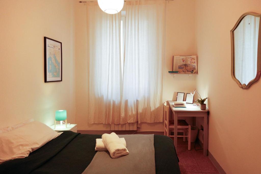 a bedroom with a bed and a desk with a mirror at Casa Pepe in Pisa
