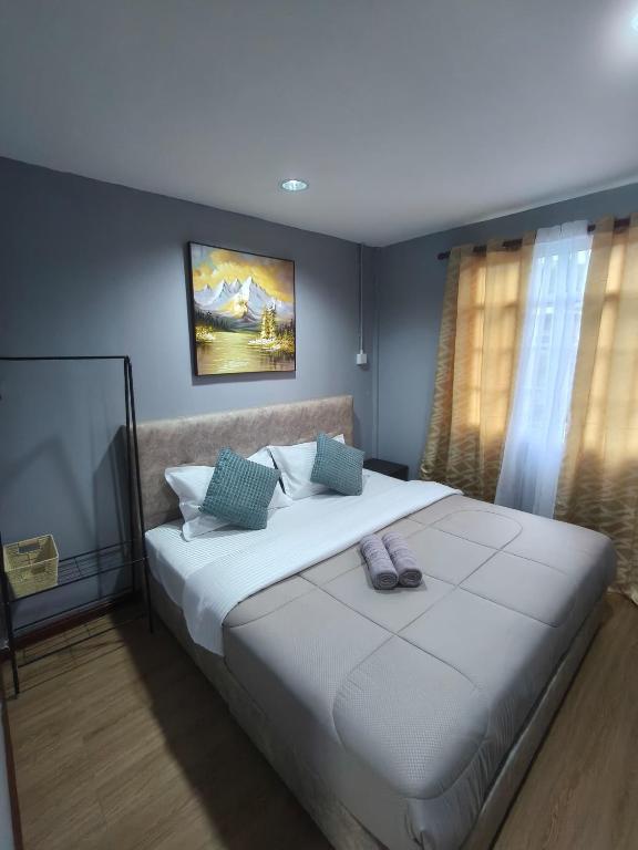 a bedroom with a large white bed with blue walls at Kundasang height valley in Ranau