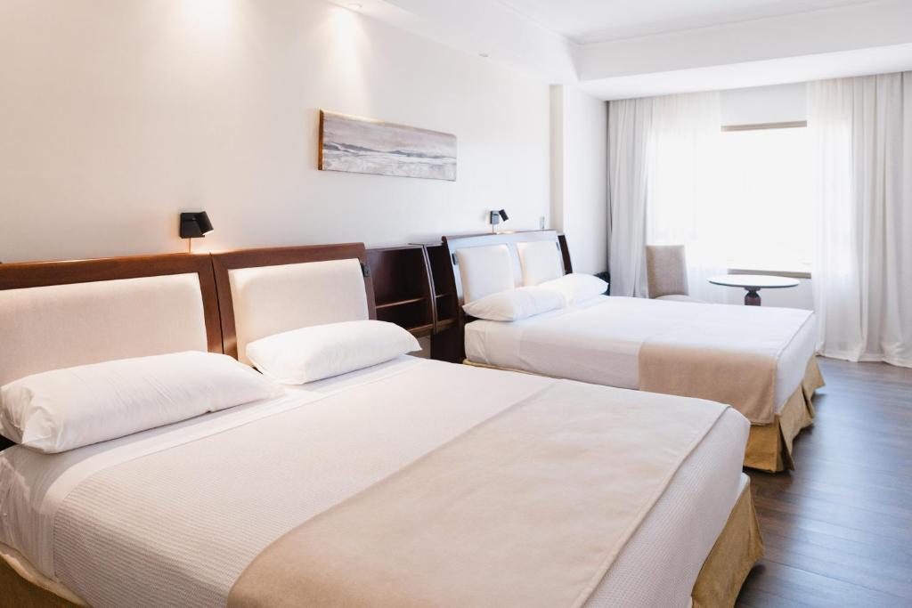 a hotel room with two beds and a window at Hotel Almería in Salta