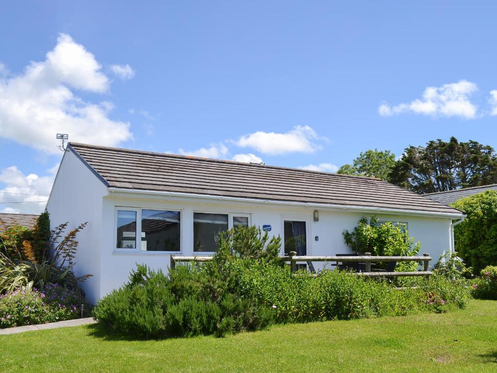 a small white house with a green yard at Treyarnon in Saint Merryn