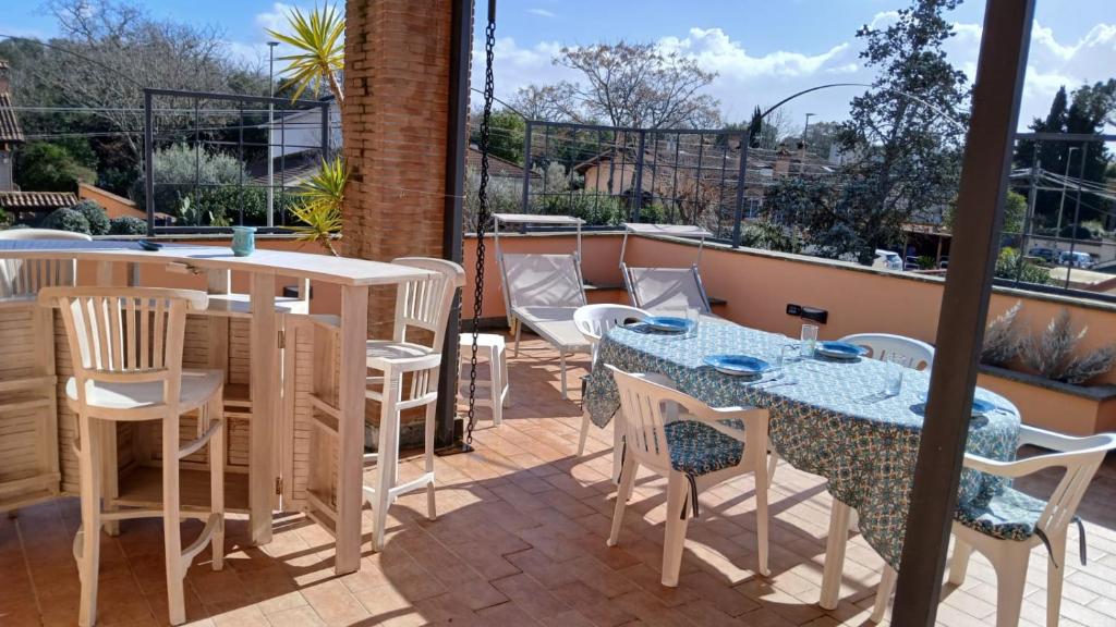 a patio with tables and chairs on a balcony at Riserva Verde in Castel Porziano