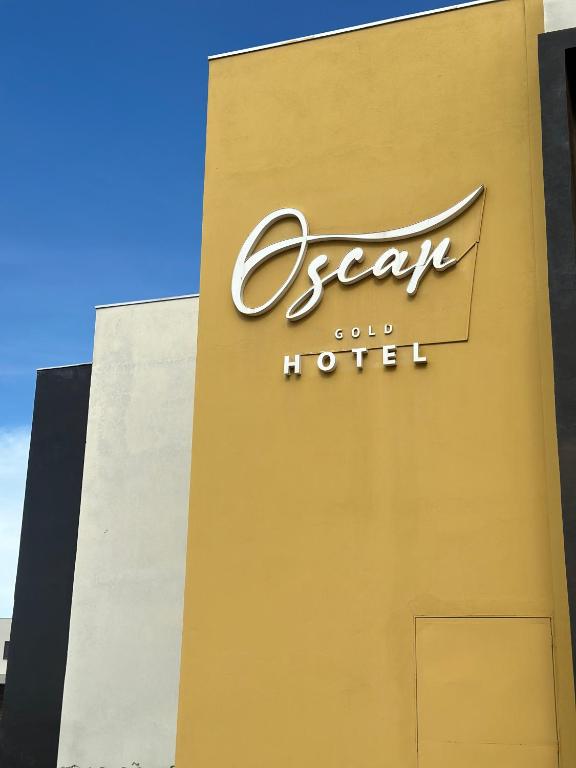 a sign for a hotel on the side of a building at Hotel Oscar Gold Janaúba in Janaúba