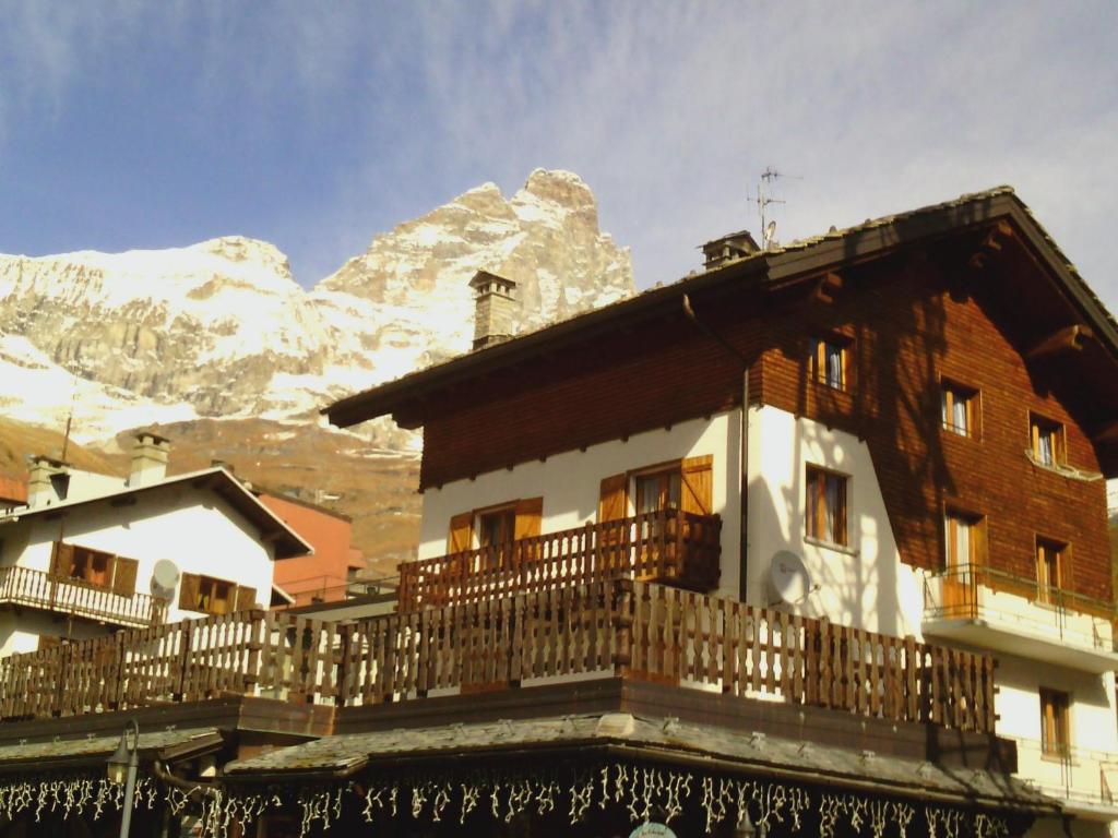 un edificio con balcón con montañas en el fondo en Cervinia en Breuil-Cervinia